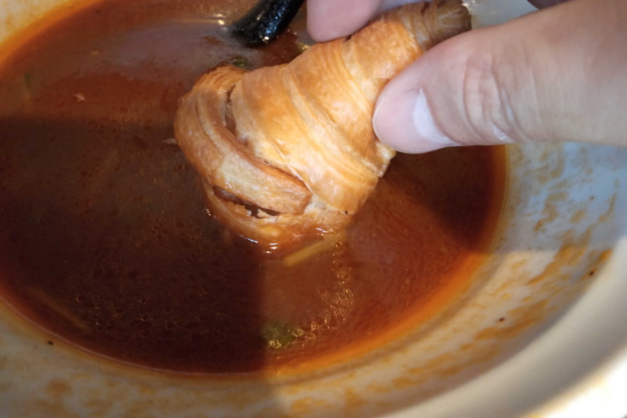 クロワッサンをスープに浸す